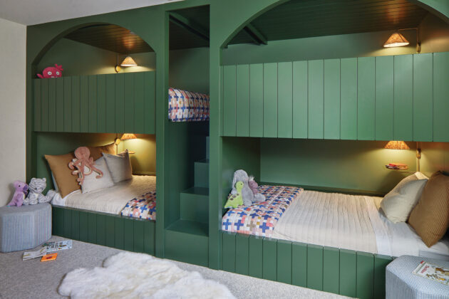 The emerald green built-in beds in the kids&rsquo; bunk room are both practical and playful, while the arched cut-out mimics the arches in the great room.
