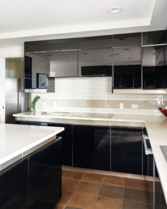 A sleek, modern kitchen where glossy cabinetry, clean lines, and refined finishes create a look that feels both dramatic and timeless.